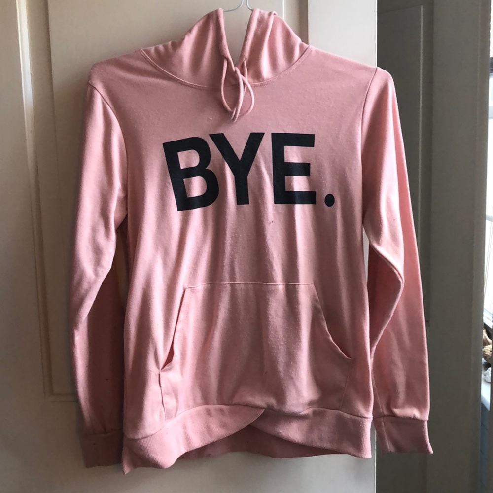 A pink sweatshirt that says bye.